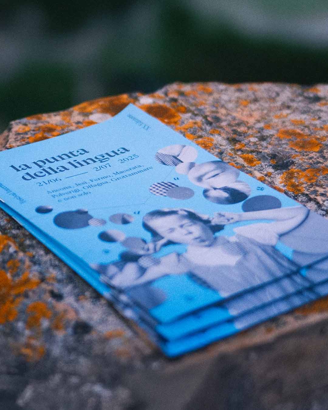 Festival catalogue placed on a table with cover design by Gianluca Abbate